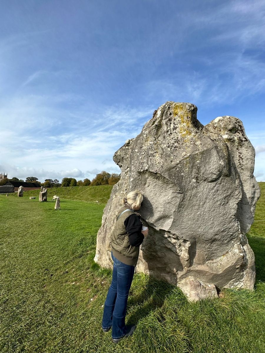 Christy listening at the standing stones at Avebury